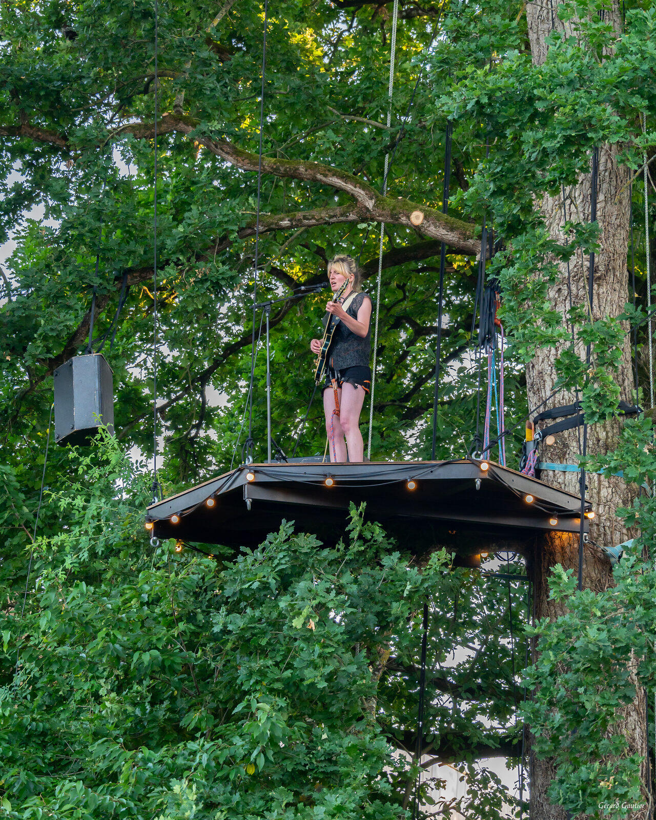 Concert perché sur L'Arborium à Auray : chanteuse guitariste sur la scène suspendue dans un chêne (Morbihan)